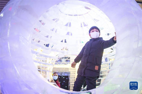 12月21日，小朋友在冰雪艺术节现场体验冰雪互动项目